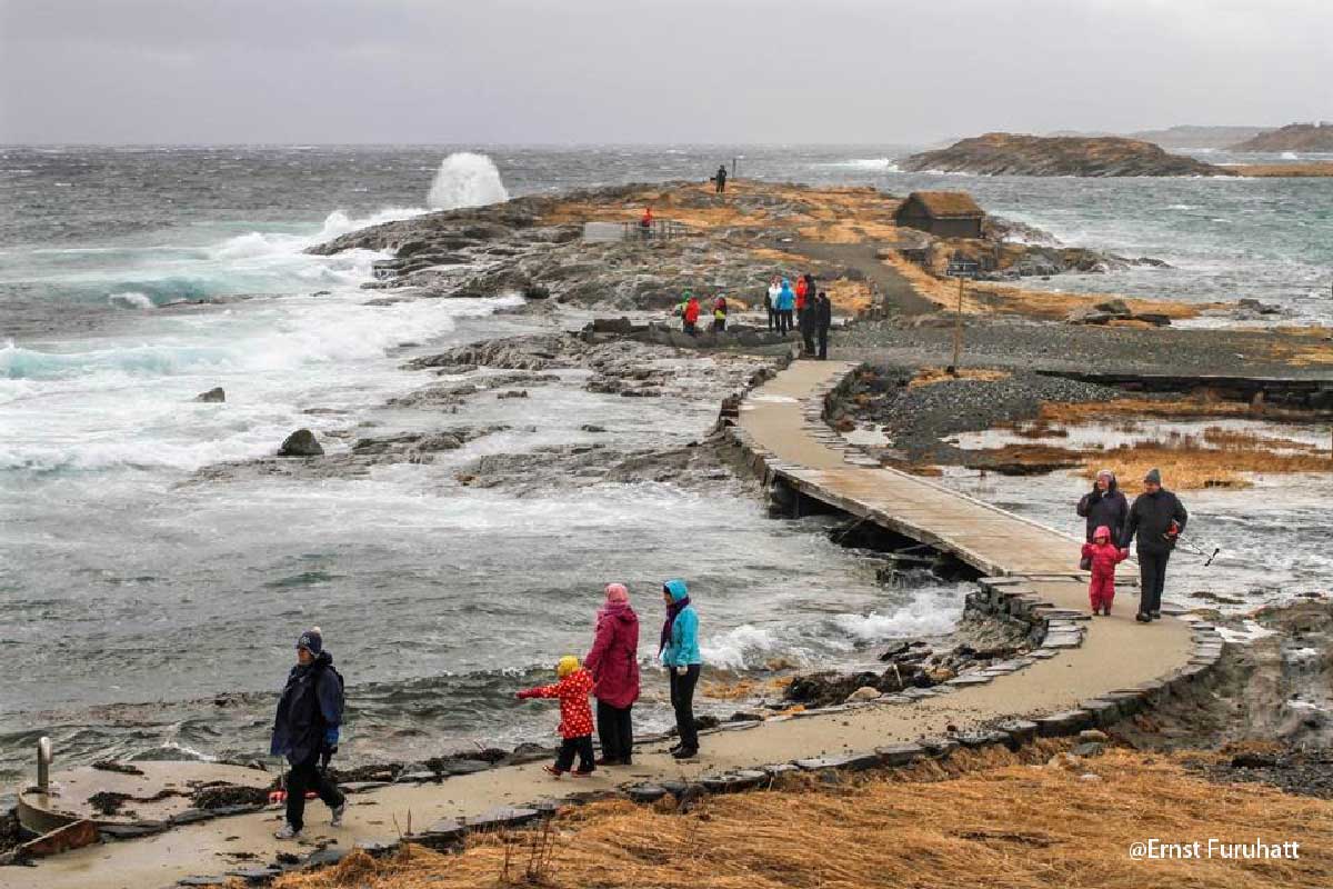 Folk på stenbro ved havet